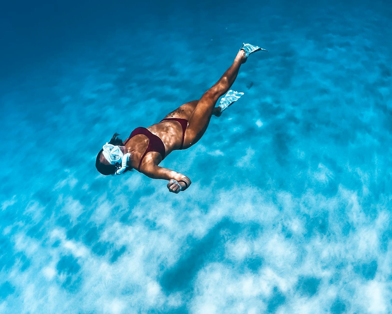 woman in black bikini swimming on blue water